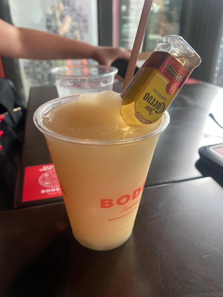 Frozen margarita topped with a mini Jose Cuervo bottle at Bodega Taqueria y Tequila, a late-night favorite in Coconut Grove


