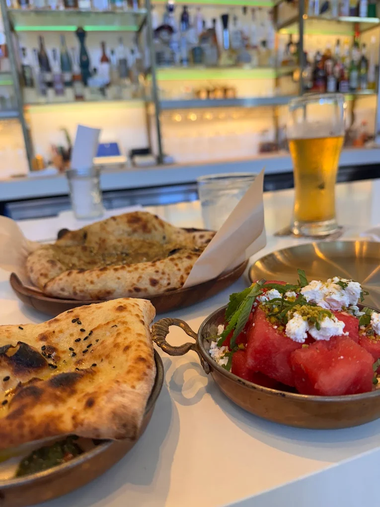 Fresh pita, labneh, and watermelon-feta salad at Motek, one of the best restaurants in Brickell
